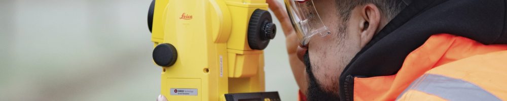 Man conducting land survey with theodolite equipment Man conducting land survey with theodolite equipment